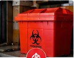 Red biohazard waste container in a controlled work area
