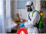 Cleanup worker in protective equipment disinfecting an indoor area